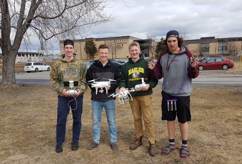 De gauche à droite, David Nash, Nathan Hoyt, Will Marshall et Brandyn Cooke, étudiants à l’école secondaire de Fredericton. En faisant appel à l’impression en 3D et à des logiciels, à la robotique, à la programmation, ainsi qu’à leurs techniques et à leur ingéniosité pour résoudre des problèmes, ce groupe a mis au point un accessoire de drone à même de prélever des échantillons d’eau. 