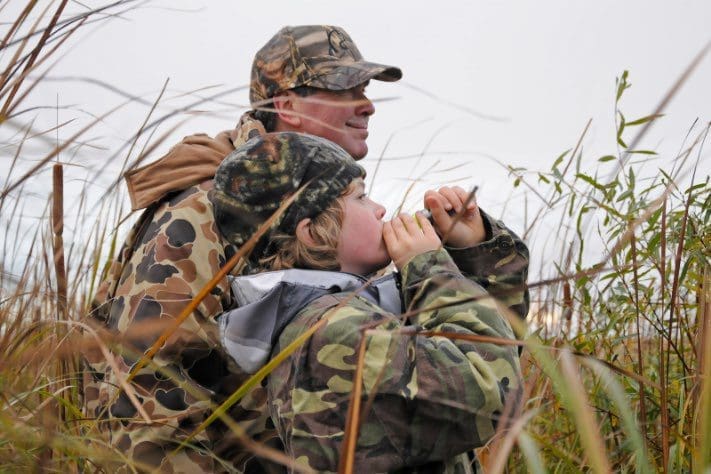 Un chasseur-mentor et son jeune protégé à l’affût pendant une expédition de chasse mentorée au Manitoba en 2014.
