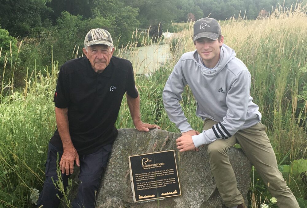 George Merry au marais de LaSalle avec son petit-fils, Angus, en 2018, flanquant la plaque honorant le don de terres de sa famille