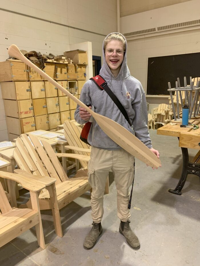 Nout, tenant une pagaie de canoë fabriquée à la main à la Charlottetown Rural High School 