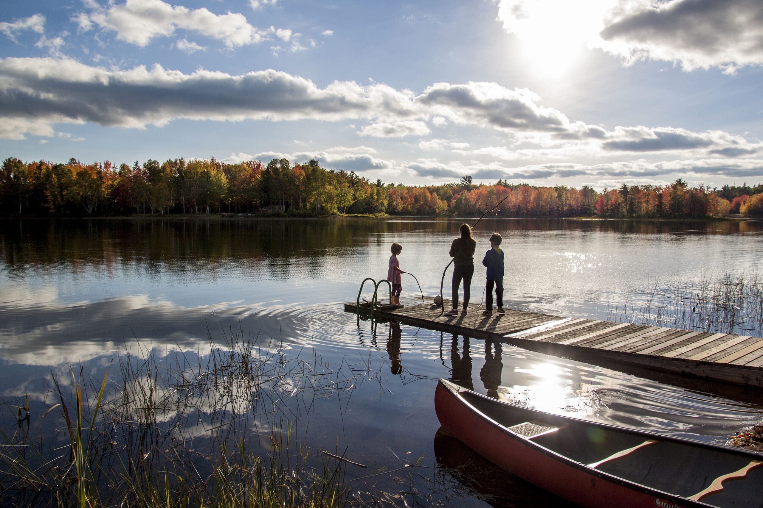 A family playing on a dock in fall.