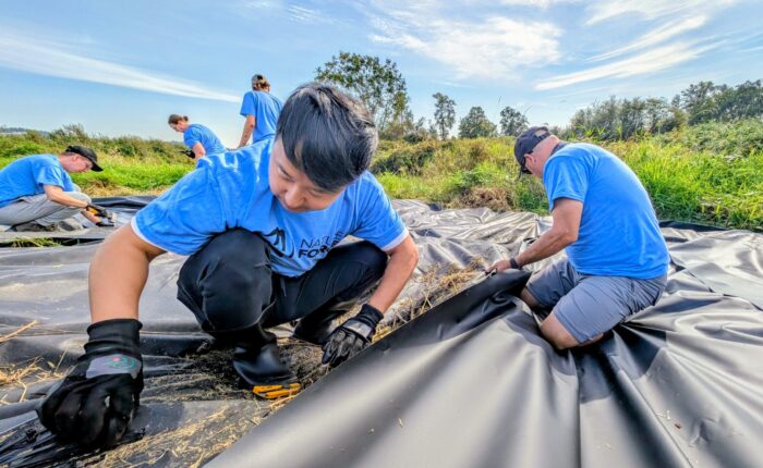 Des bénévoles de Force de la nature aident à installer une barrière benthique à Pitt Addington Point, dans les basses-terres continentales, en Colombie-Britannique. 