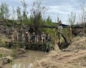 L’équipe de terrain de CIC pose devant un barrage de castor factice nouvellement construit. 
