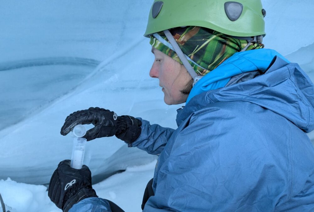 Emily Moss, membre de l’équipe d’expédition et experte en ressources naturelles, prélève un échantillon de glace de glacier en vue d’une analyse biologique.