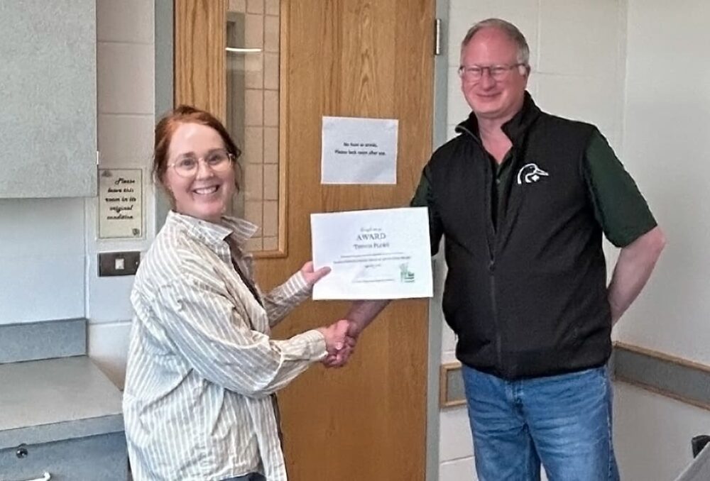 Brooke Howat (proposante) remet à Trevor Plews le prix Forage Industry Innovation lors de l’AGA du Saskatchewan Forage Council le 24 juin 2026.